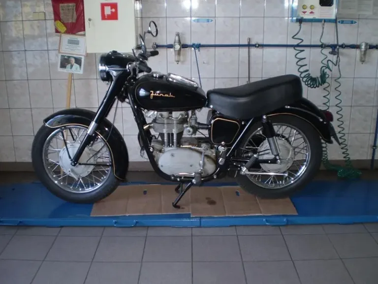 Zabytkowy motocykl Junak w hali firmy podczas rajdu